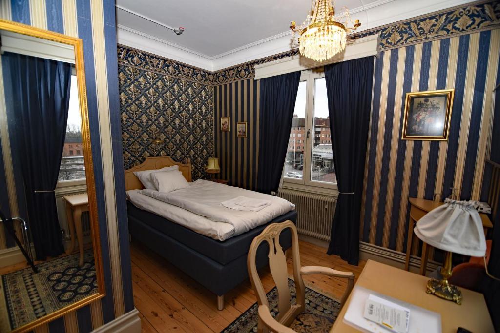 A bed or beds in a room at Park Hotel Linköping Fawlty Towers