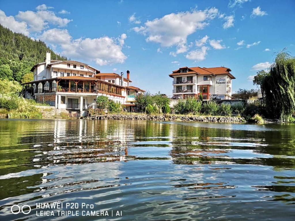 a group of houses on the banks of a river at Ribkata Family Hotel in Smolyan