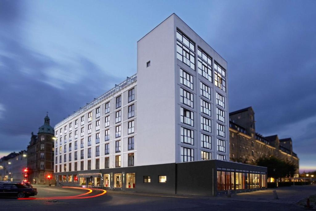 a tall white building on a city street at night at Scandic Front in Copenhagen