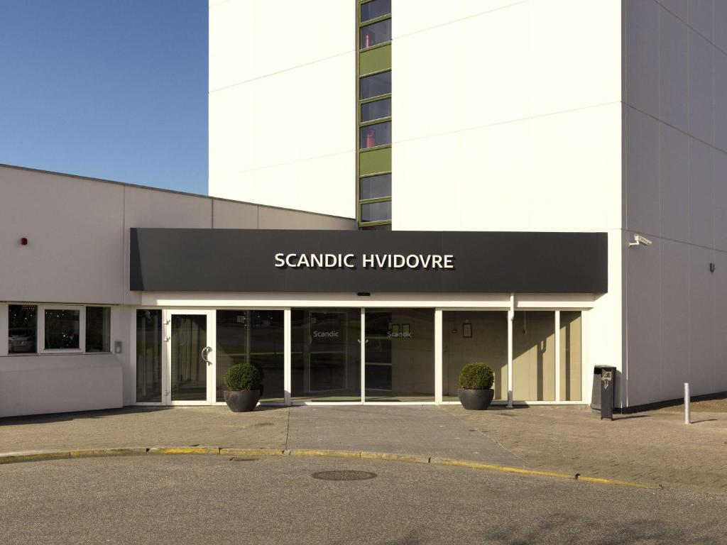 un grande edificio con un cartello che legge l'innovazione del senato di Scandic Hvidovre a Hvidovre