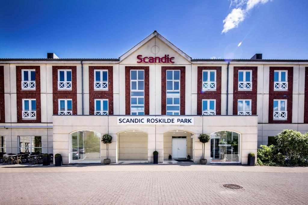 un gran edificio de ladrillo con el nombre de parque ansicsnsics en Scandic Roskilde Park, en Roskilde