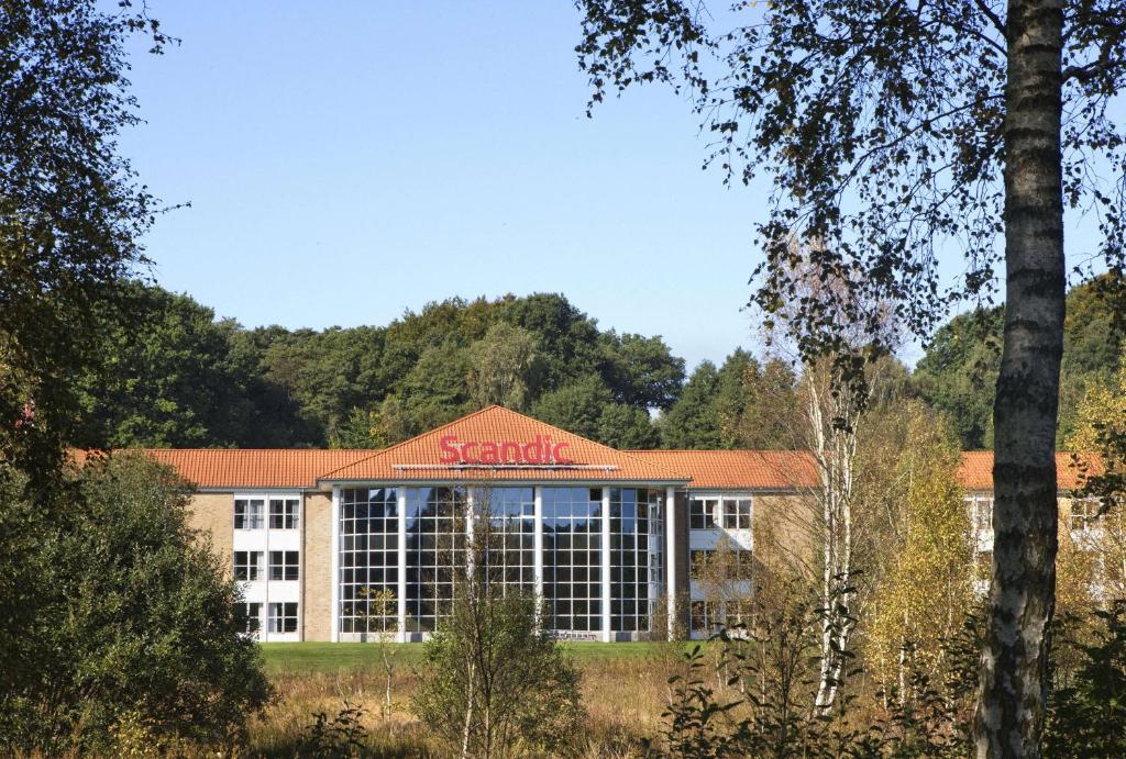 un gran edificio con un cartel de scania en Scandic Silkeborg en Silkeborg