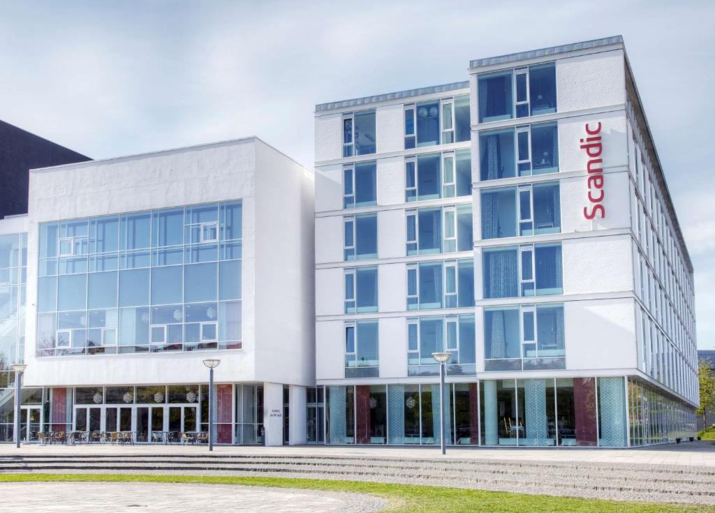 a large white building with a red sign on it at Scandic Jacob Gade in Vejle