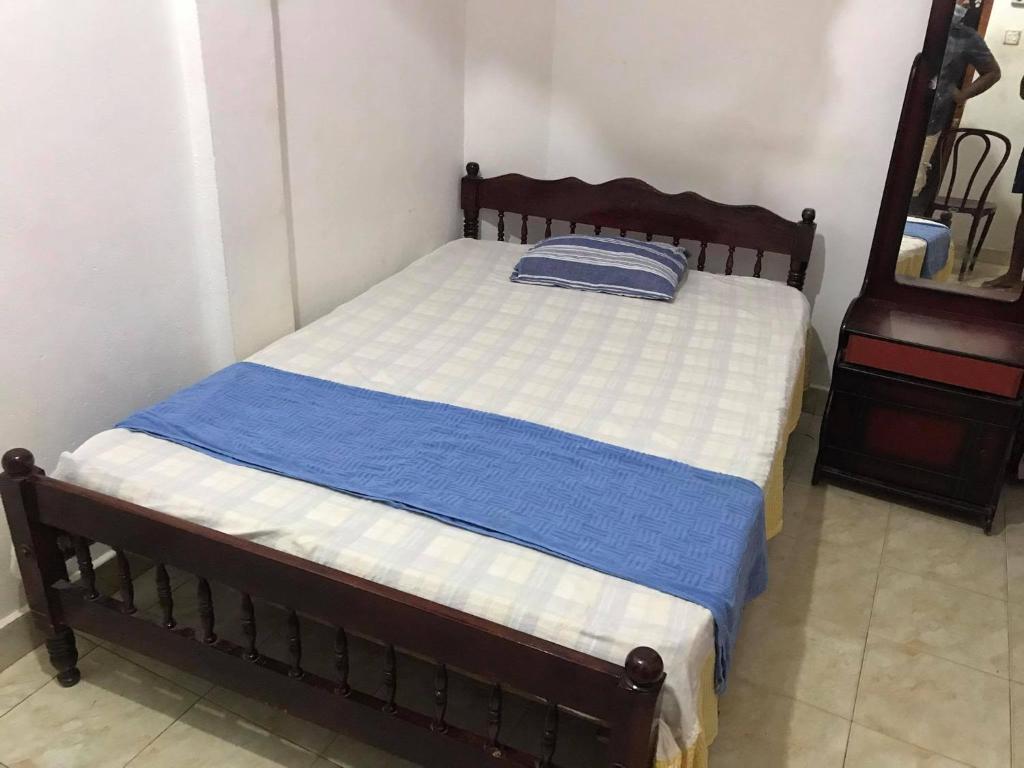 1 dormitorio con 1 cama con manta azul y blanca en Tharuka Rest Inn Hotel, en Tanamalwila
