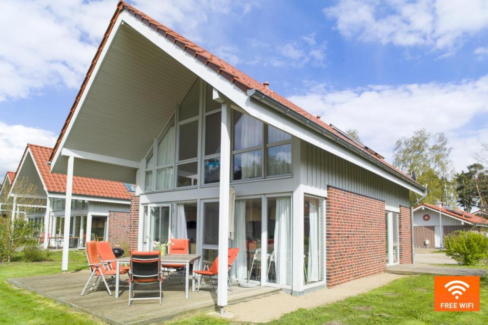 een huis met een serre met een tafel en stoelen bij W8 - wundervolles Ferienhaus in der Natur in Röbel an der Müritz in Röbel