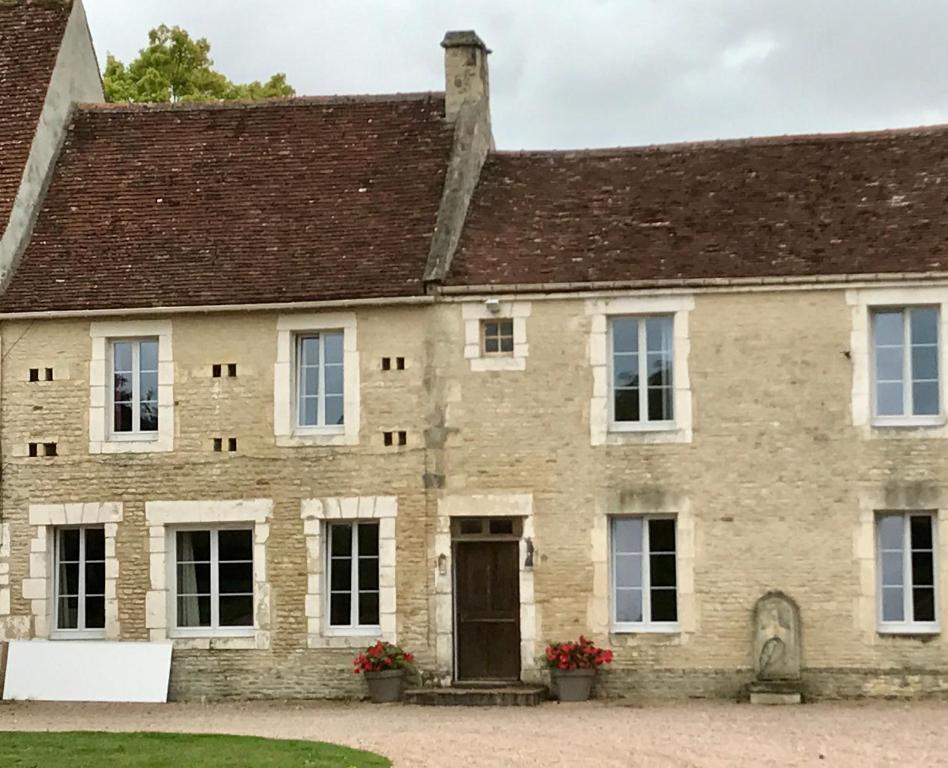 ein altes Steinhaus mit braunem Dach in der Unterkunft la ferme, Coeur De Combray in Ernes