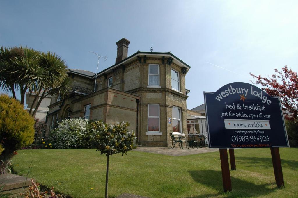 una señal frente a una casa con una casa en Westbury Lodge en Shanklin