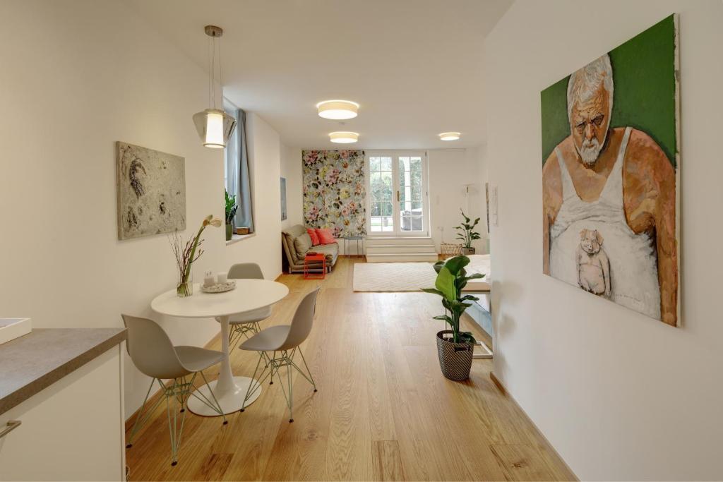 a living room with a table and a painting on the wall at Boutique Apartments Freiburg - Elsa in Freiburg im Breisgau