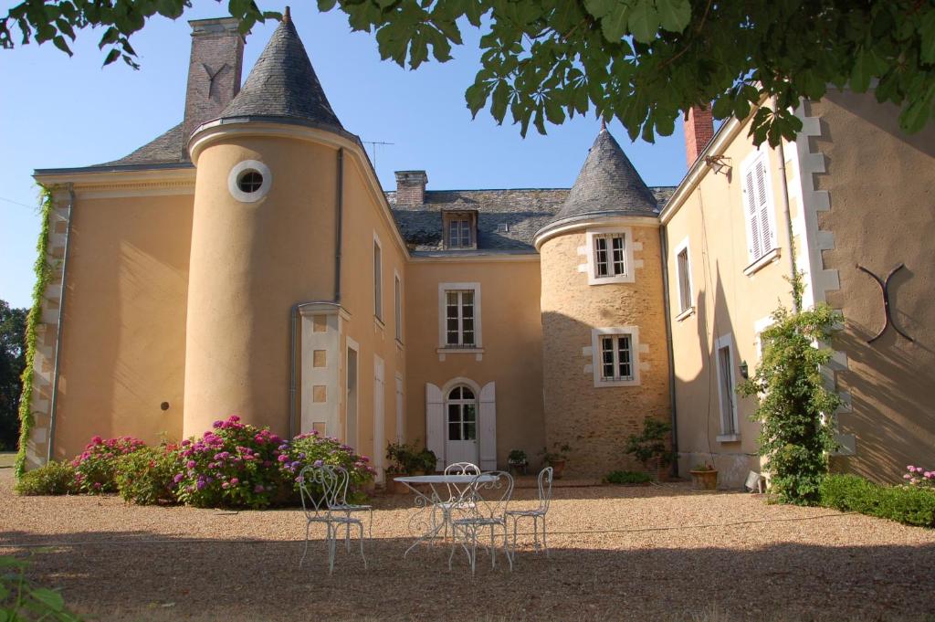 a house with a table and chairs in front of it at Château des Lutz in Daon