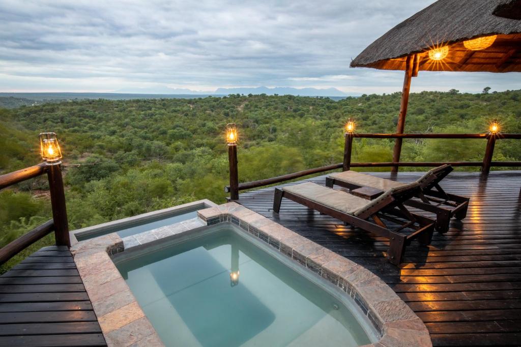 einen Whirlpool auf einer Terrasse mit einem Tisch und Bänken in der Unterkunft Parsons Hilltop Safari Camp in Balule Game Reserve