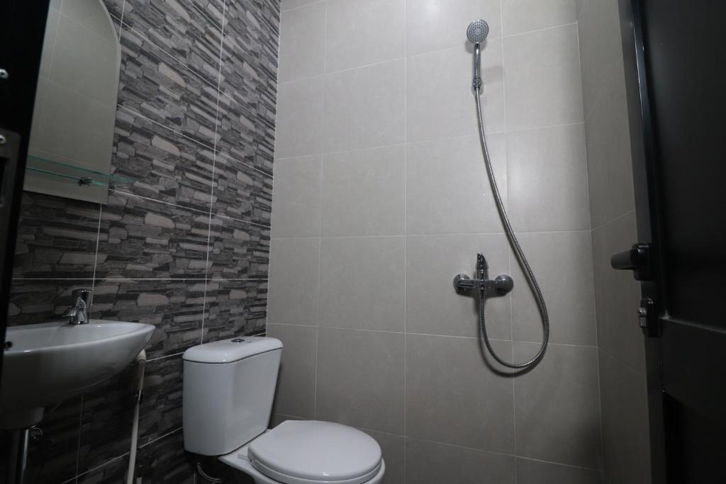 un bagno con doccia, WC e lavandino di The Cabin Tanjung Yogyakarta a Yogyakarta