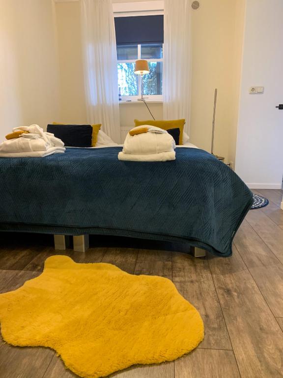 a bedroom with a large bed with a yellow rug at Harlingen Garden Apartment in Midlum