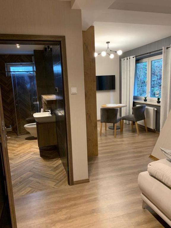 a living room with a couch and a dining room at Kurort Kozubnik Apartament 12 in Porąbka