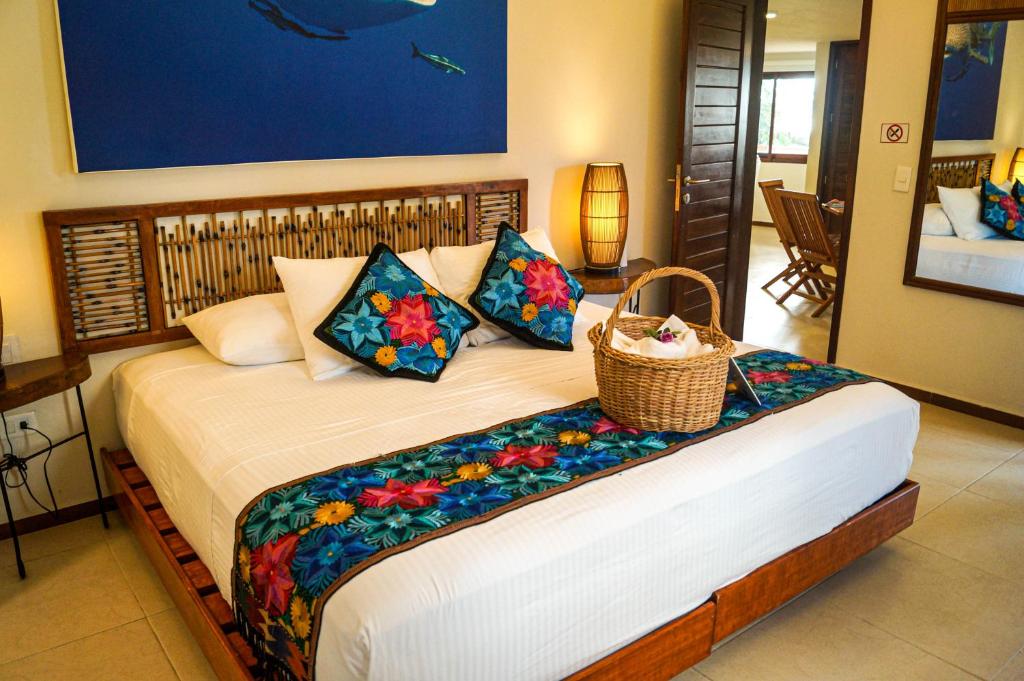 a bedroom with a bed with a basket on it at Casa Azul Maya in Isla Mujeres