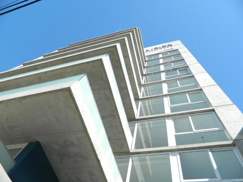 un edificio blanco alto con muchas ventanas en Vizion Hollywood Apartments en Buenos Aires