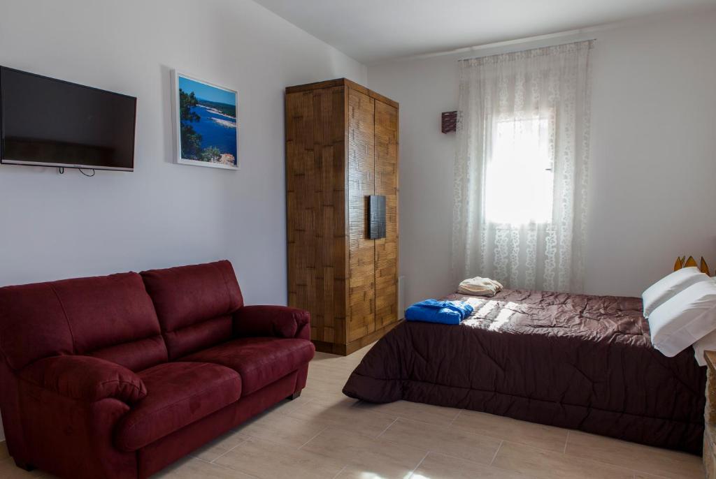 a living room with a couch and a bed at Calasole Country House in Torre Lapillo
