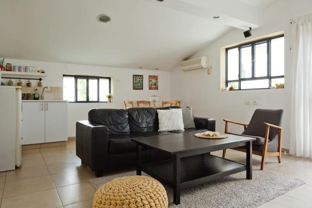 a living room with a black couch and a table at Judith's Place - Stylish Apartments in Ramat Gan