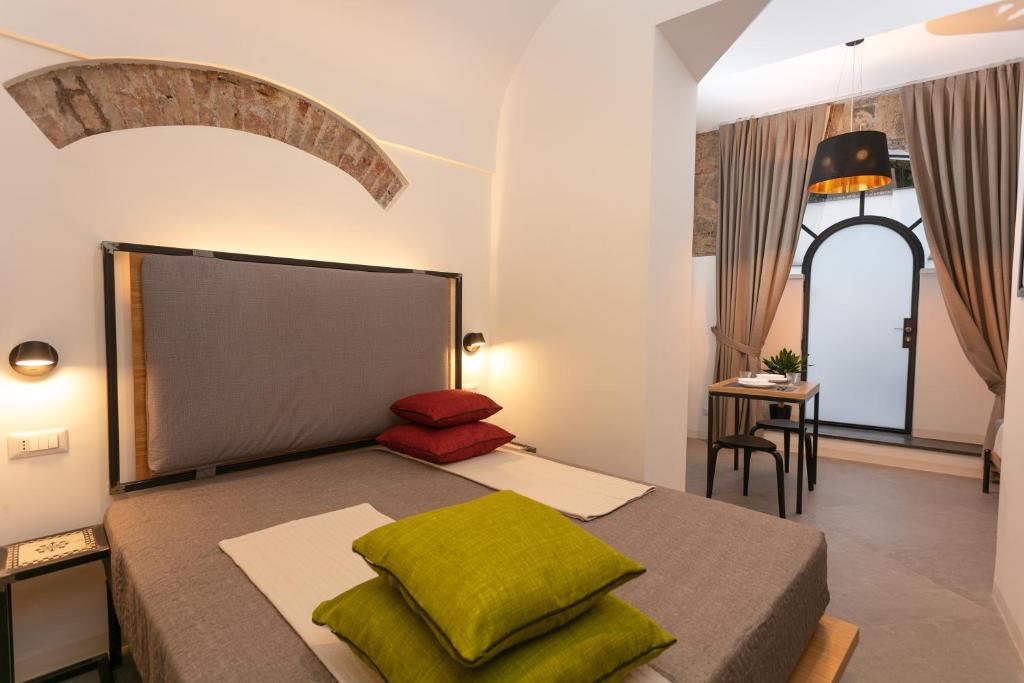 a bedroom with a bed with green pillows at Bellamania B&B in Anacapri
