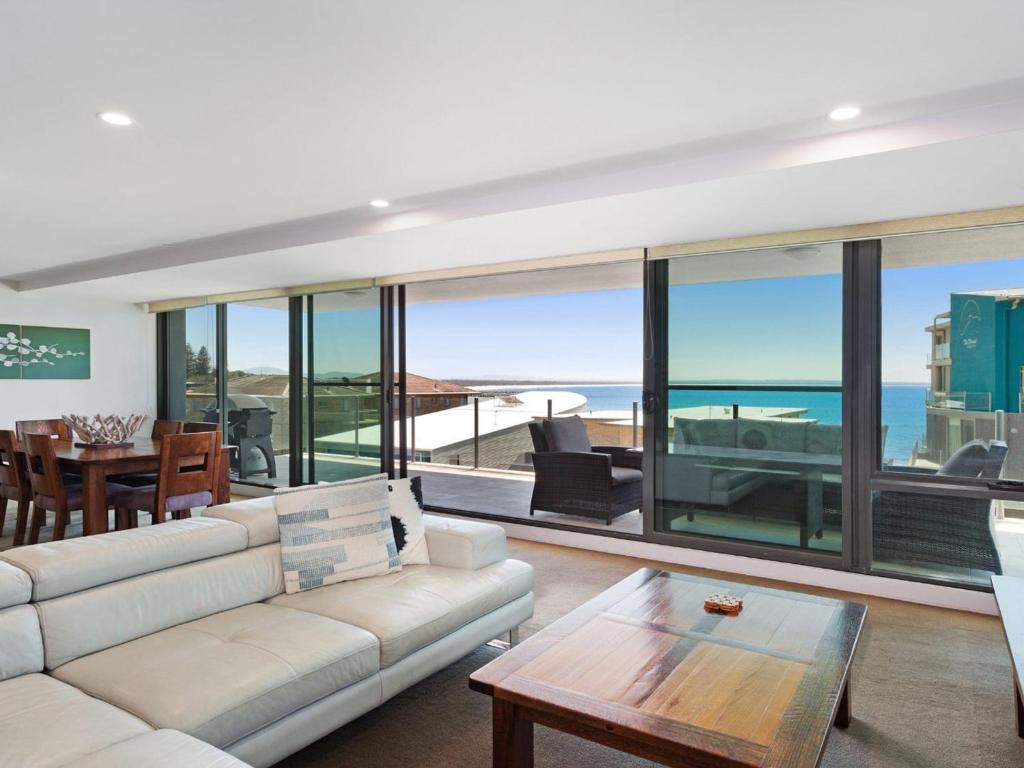 ein Wohnzimmer mit einem Sofa und einem Tisch in der Unterkunft Strand Beachside 503 in Forster
