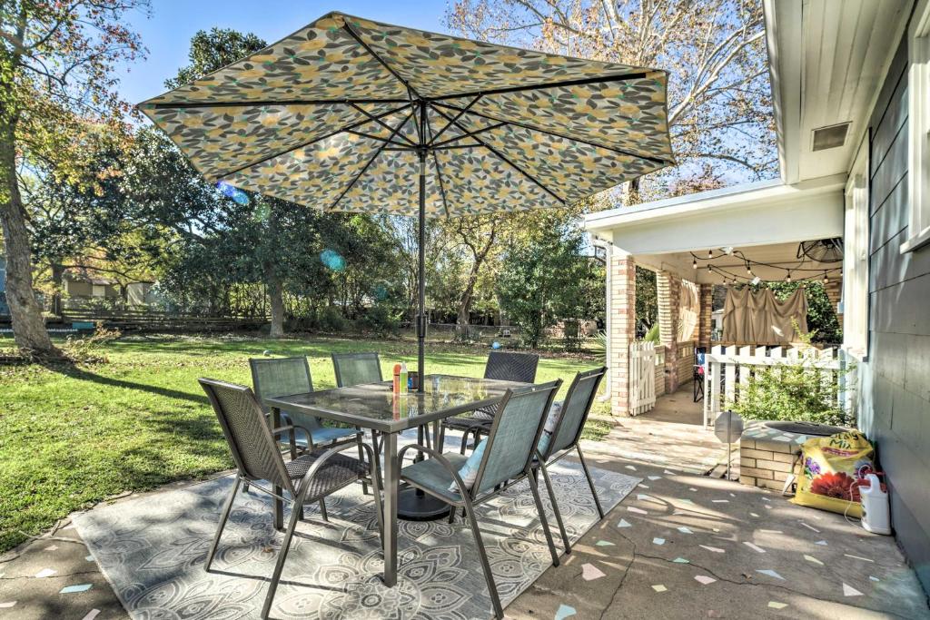 a table with chairs and an umbrella on a patio at Brenham Bungalow with Yard, 1 Mi to Downtown! in Brenham