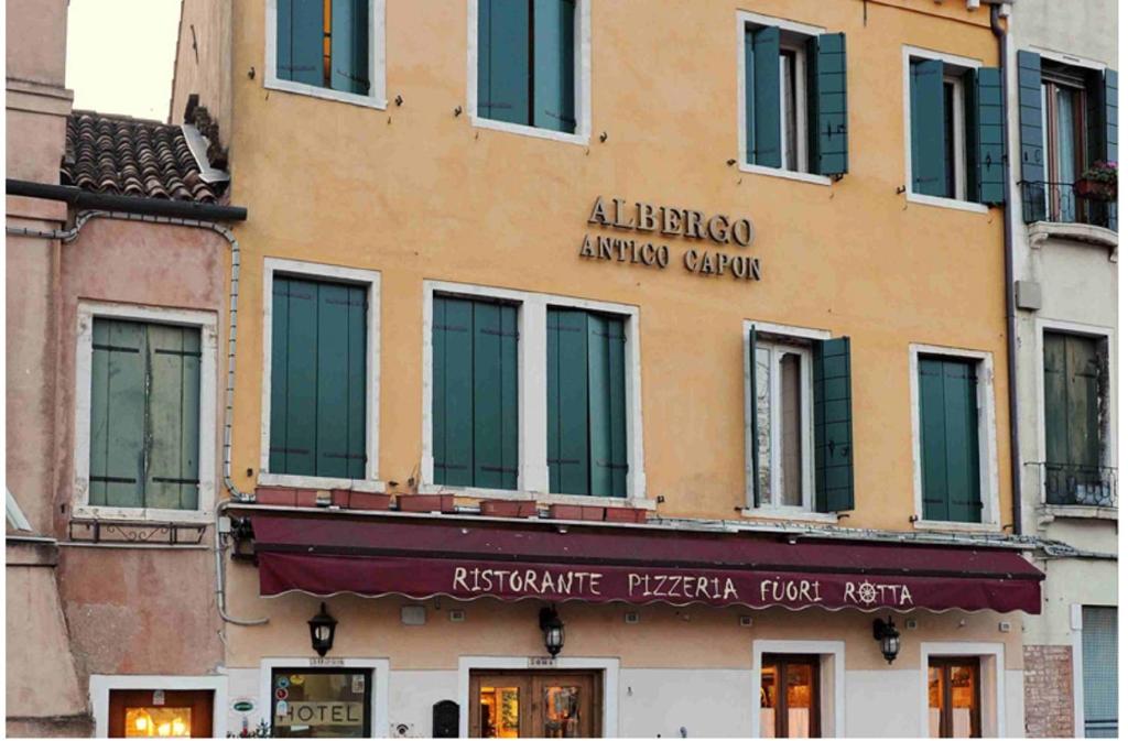 a building with a sign on the side of it at Hotel Antico Capon in Venice