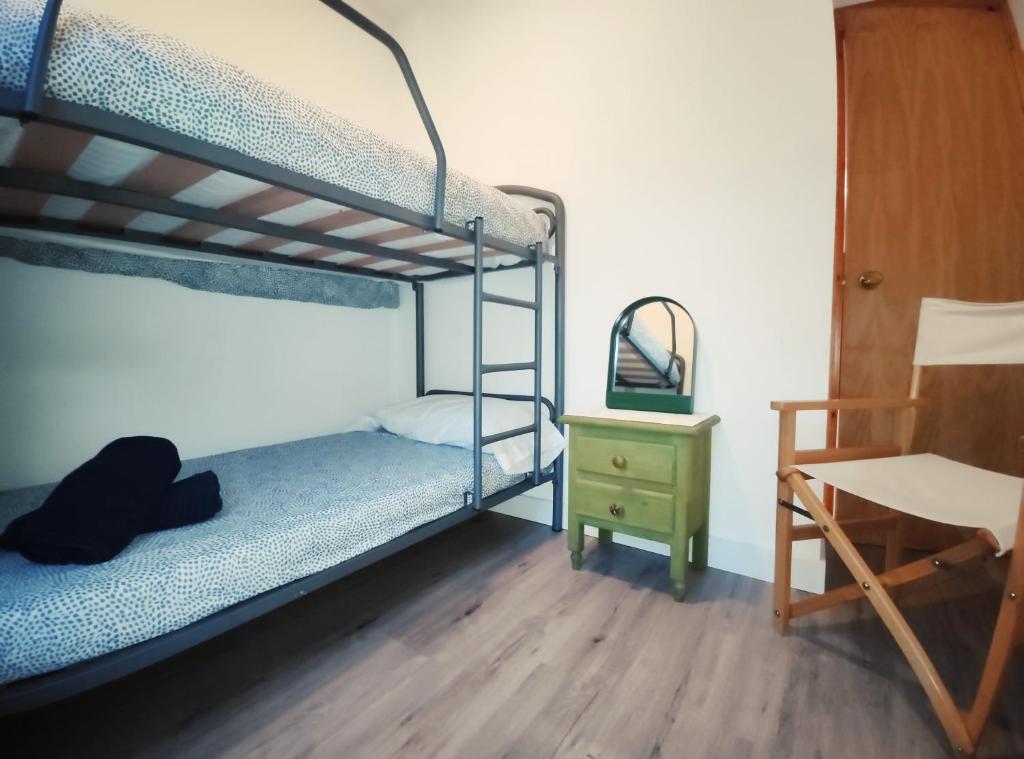 a bedroom with two bunk beds and a desk at el rincon de collarada in Villanúa