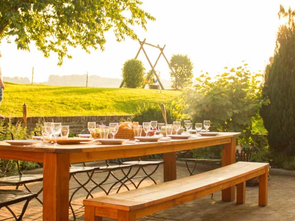 un tavolo di legno con bicchieri e cibo sopra di Lush Mansion in Voeren with Private Garden a Voeren