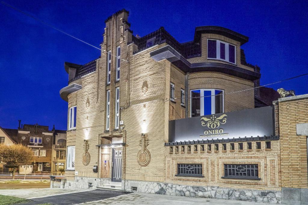 a large brick building with a sign on it at ONIRO - Luxury Rooms & Wellness Suites in Tournai