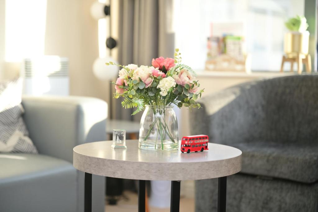 a vase of flowers on a table in a living room at TcA in Watford