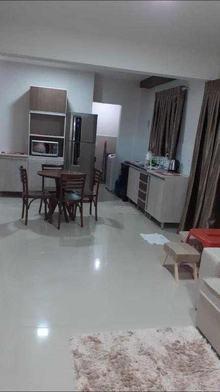 a kitchen and living room with a table and chairs at Apartamento in Bombinhas