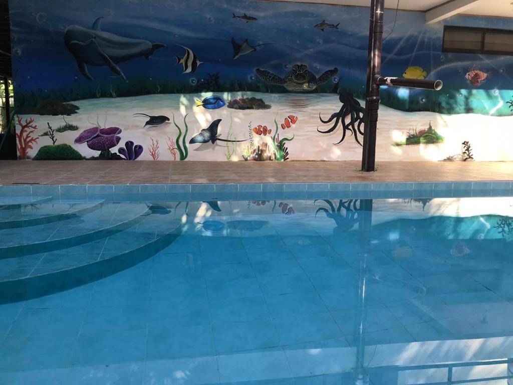 una gran piscina con un acuario de fondo en Be My Guest Cabinas, en Puerto Viejo