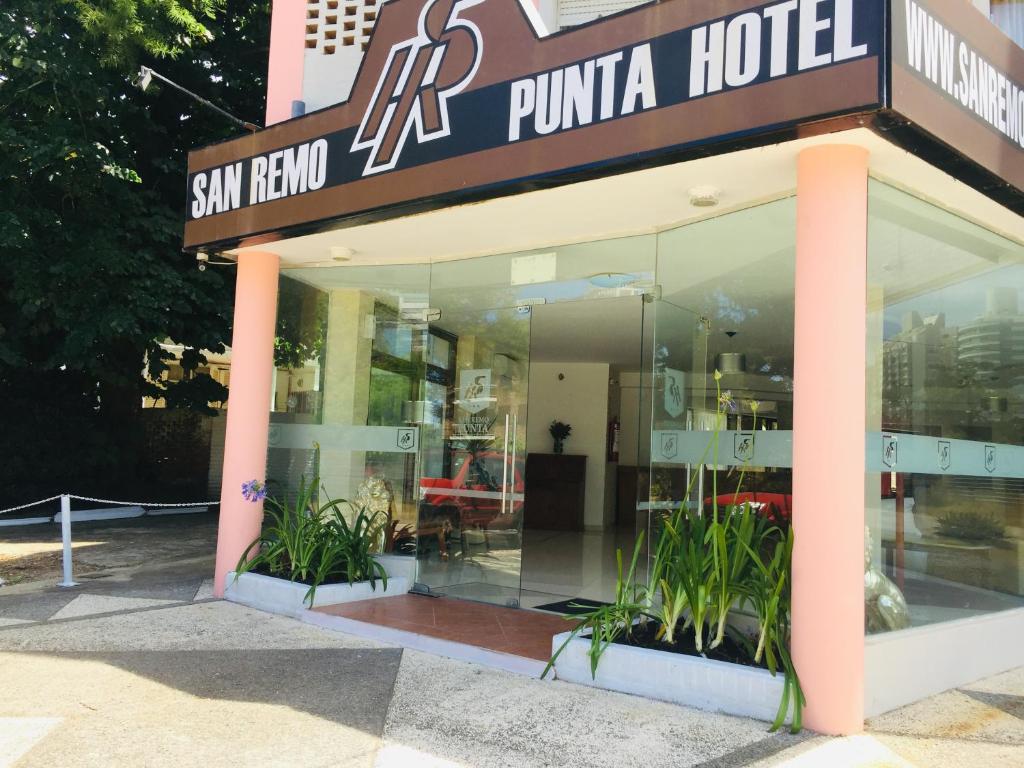 uma loja em frente a um hotel puma com plantas em San Remo Punta Hotel em Punta del Este