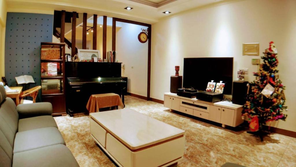 ein Wohnzimmer mit einem Weihnachtsbaum und einer Couch in der Unterkunft Home is Love house Homestay in Chaozhou