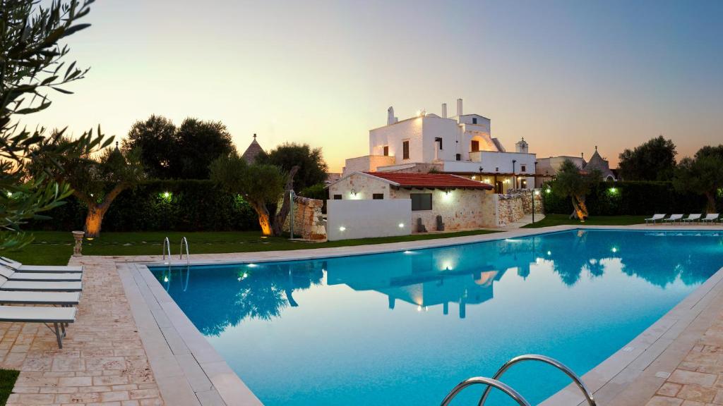 een zwembad met een huis op de achtergrond bij Masseria Madonna dell'Arco Agriturismo in Martina Franca