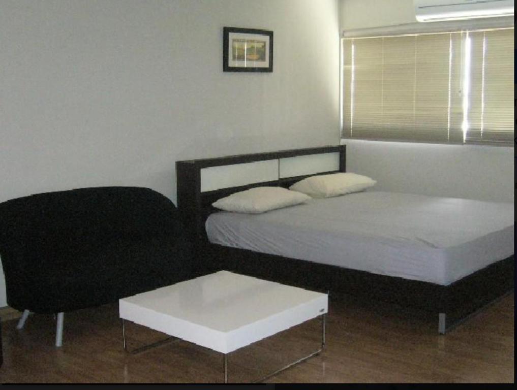 um quarto com 2 camas e uma cadeira em Family Room Dmk Don mueang Airport 2 bedrooms em Ban Bang Phang