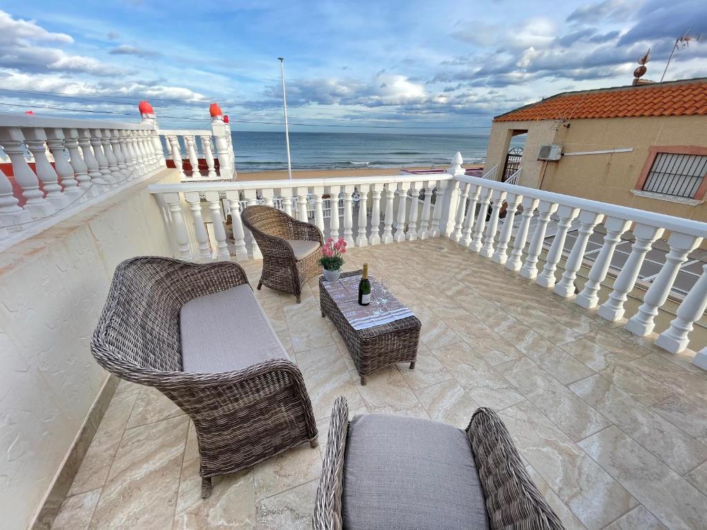 a balcony with chairs and a table and the ocean at Royal Beach House Vista Mar in La Mata