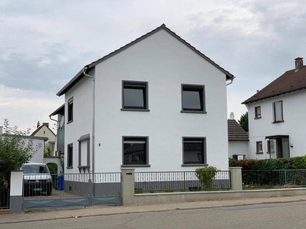 une maison blanche avec des fenêtres noires et une clôture dans l'établissement My-Skypalace Dirmstein, à Dirmstein