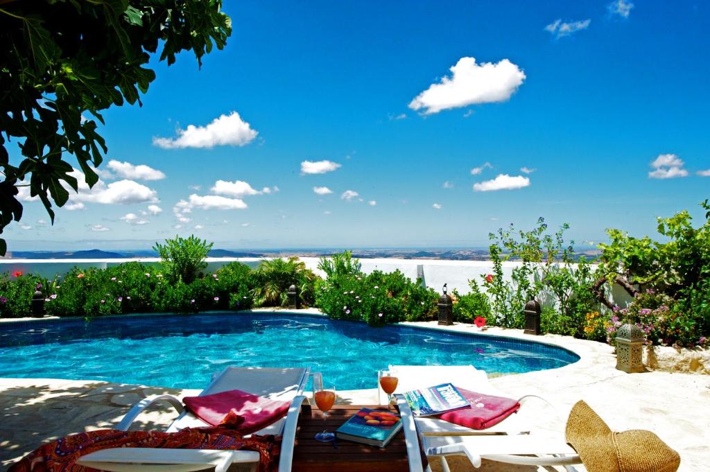 a swimming pool with a table and chairs next to it at La Vista de Medina Studios & Apartments in Medina Sidonia