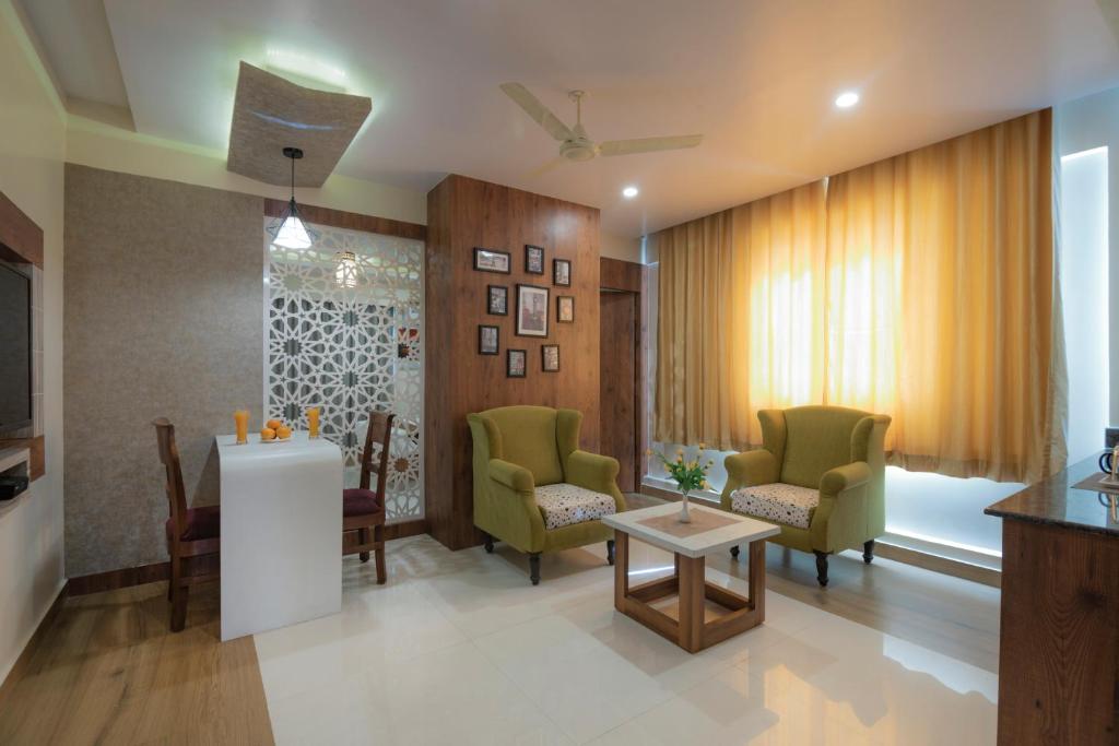 a living room with two chairs and a table at Hotel Monarch By Rivido, Bannerghatta Main Road in Bangalore