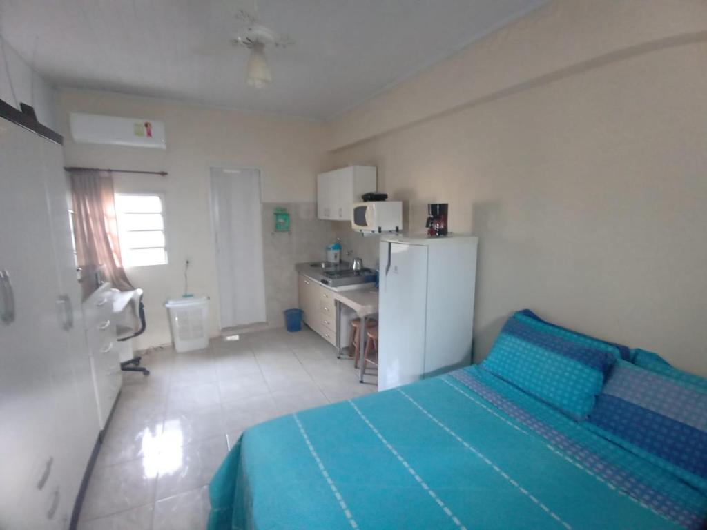 a bedroom with a blue bed and a sink at Pousada da Tetê in Porto Alegre