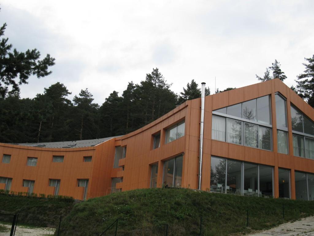 an orange building with glass windows at Family Hotel The Body in Batak