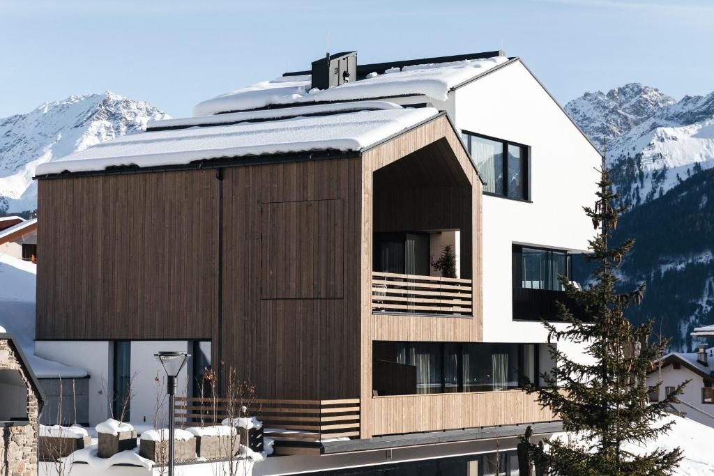 een huis met een houten gevel in de sneeuw bij The one and only in Serfaus