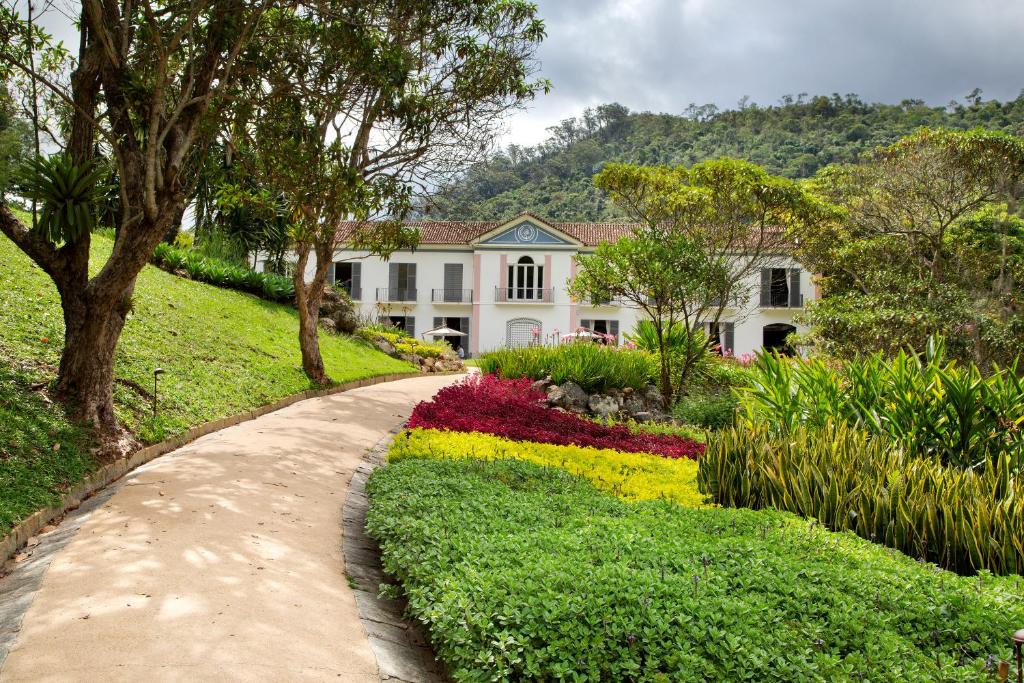 un giardino di fronte a una casa bianca con fiori di Casa Marambaia Hotel a Petrópolis