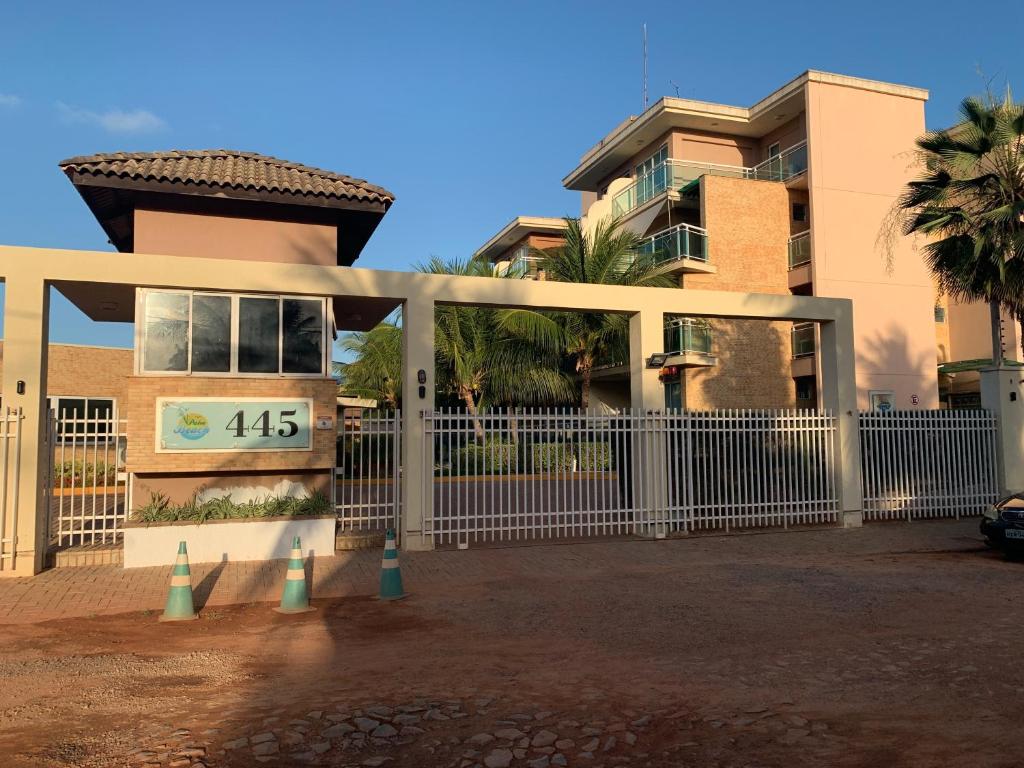 a gate in front of a building with a house at Palm Beach Residence in Aquiraz