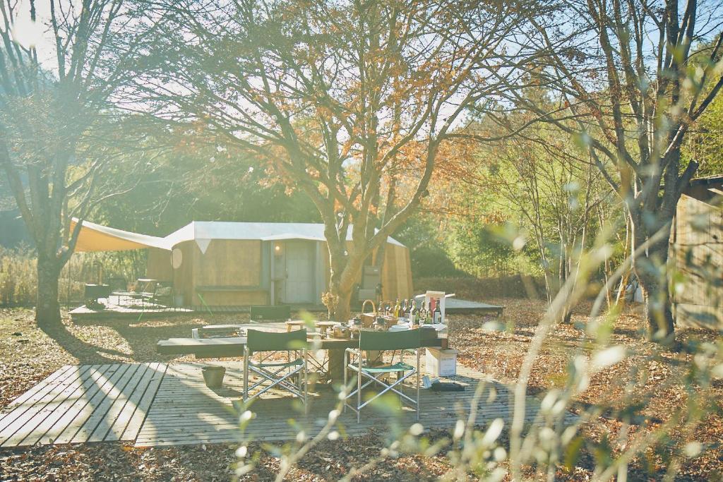 einen Picknicktisch und Stühle in einem Hof mit Schuppen in der Unterkunft LOOF Tiny House Camp in Fuefuki