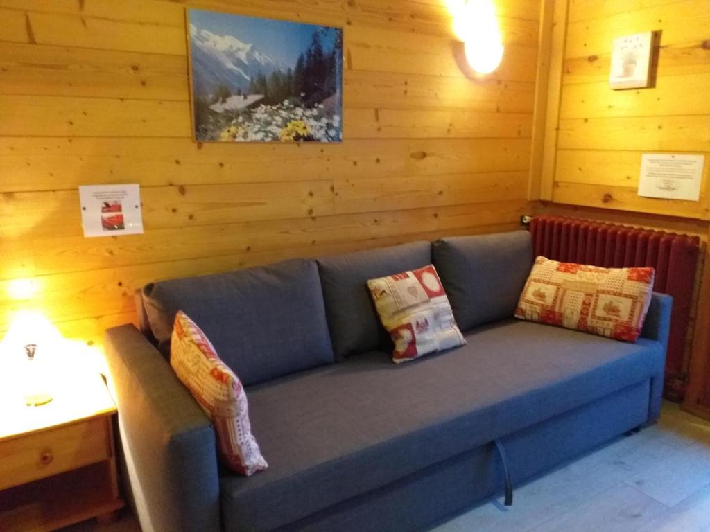 Sofá azul en una habitación con paredes de madera en Chalet Plein Sud en Montgenèvre