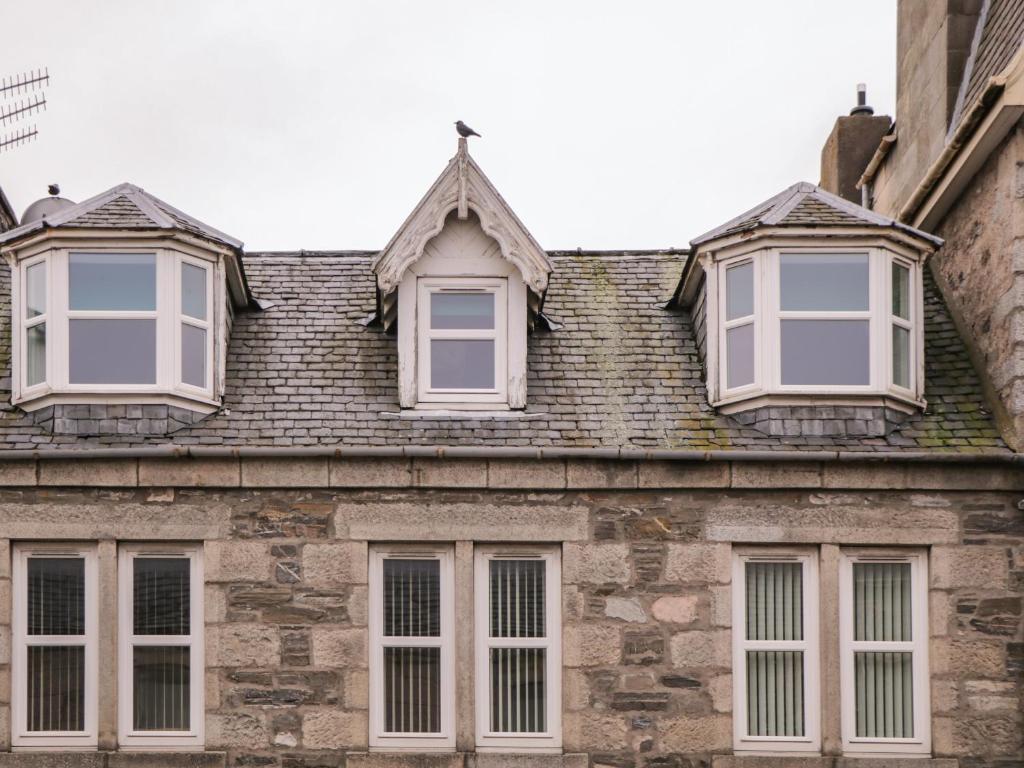 3 ventanas en el techo de un edificio antiguo en Kinnaird House, en Grantown-on-Spey