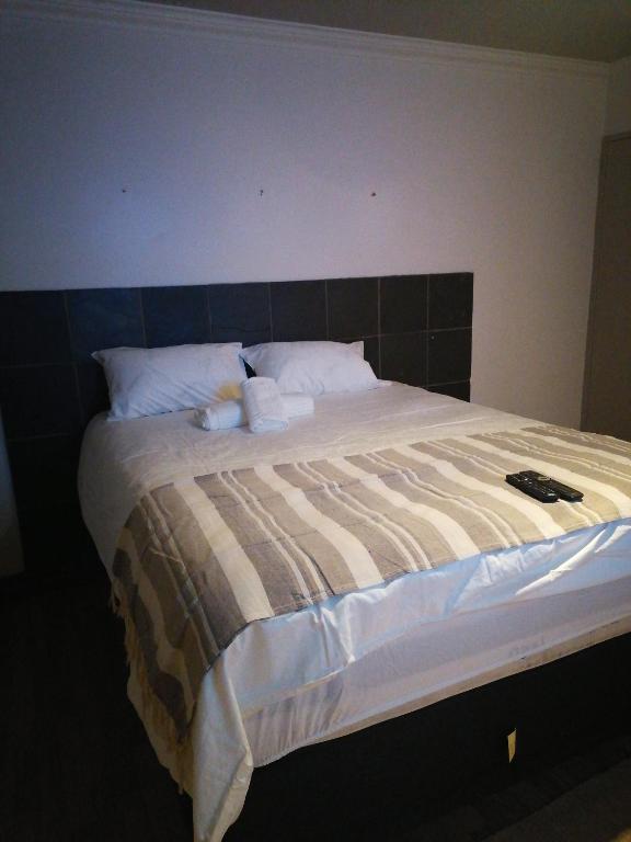 een slaapkamer met een groot bed met een zwart hoofdeinde bij 180 On Anderson Guest House in Pretoria