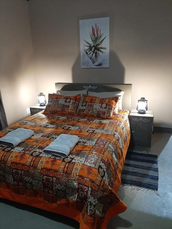 a bedroom with a large bed and two night stands at Denmark Farm Stay in Cradock