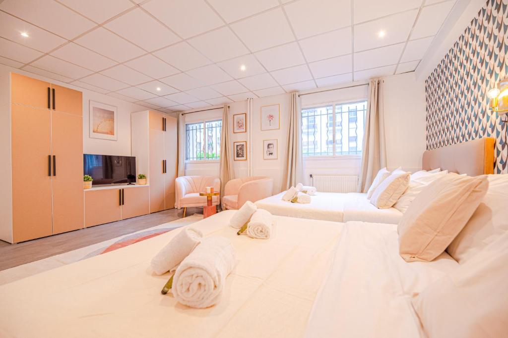 a white room with a large bed and a living room at Luxury flat- Eiffel tower in Paris